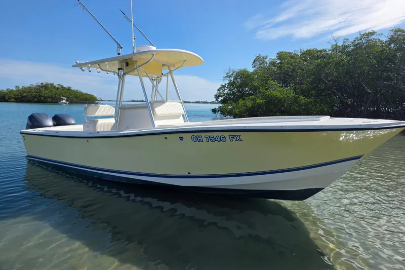 Slide: The Image of 2002 Regulator 26 Center Console boat in calm waters, surrounded by lush greenery. - 4