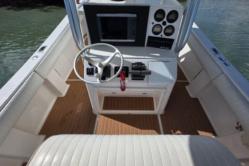 Slide: The Image of 2002 Regulator 26 Center Console boat interior with steering wheel and control panel. - 14