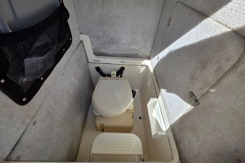 Slide: The Image of 2002 Regulator 26 Center Console boat interior with compact marine toilet. - 16