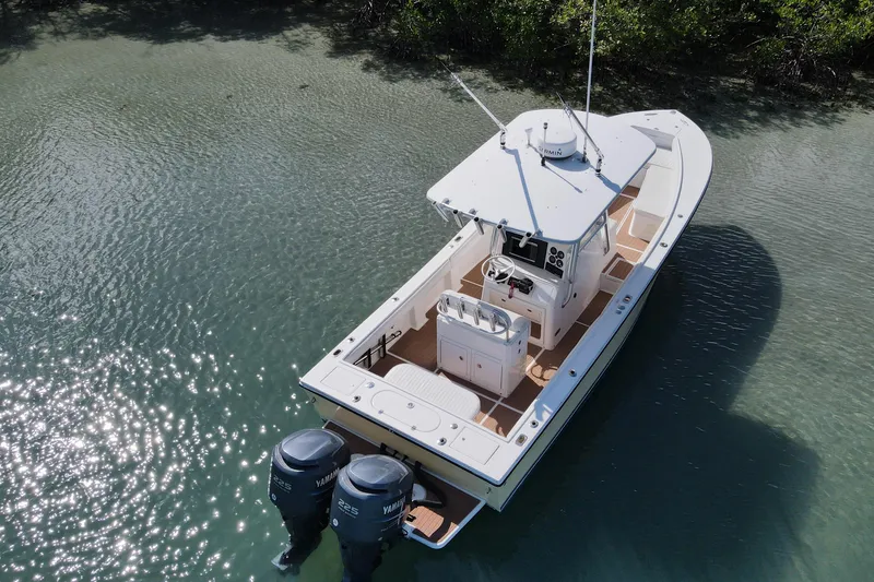 Slide: The Image of 2002 Regulator 26 Center Console boat on clear water, featuring twin Yamaha engines. - 7