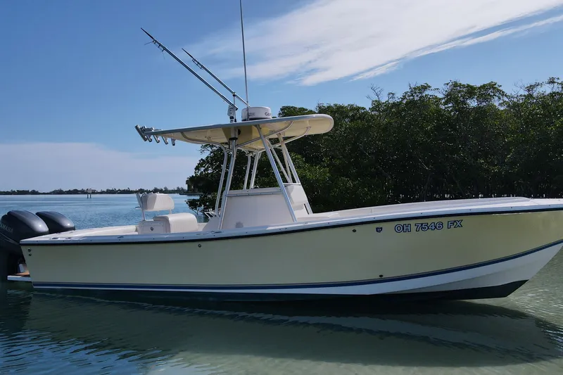 Slide: The Image of 2002 Regulator 26 Center Console boat on calm water, featuring dual engines. - 5