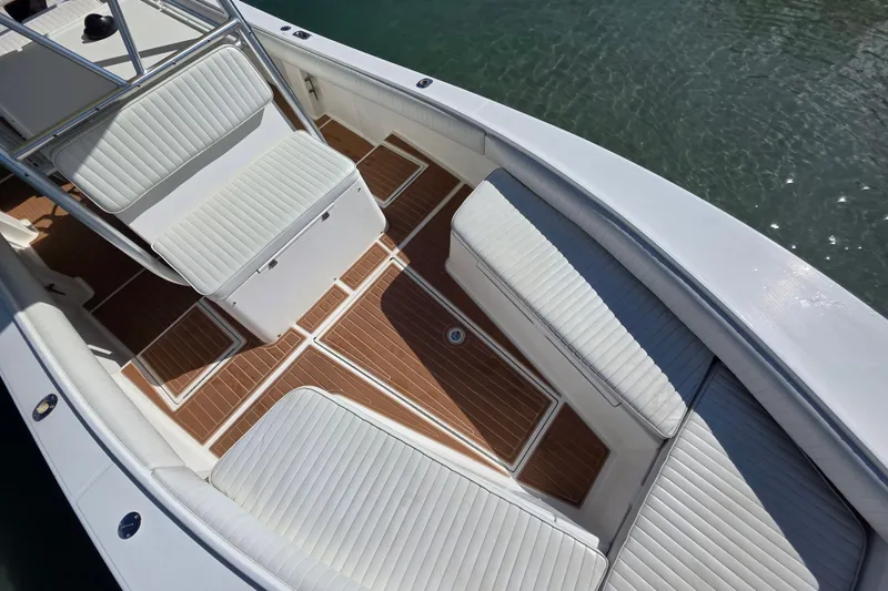 Slide: The Image of 2002 Regulator 26 Center Console boat interior with white seating and teak flooring. - 10