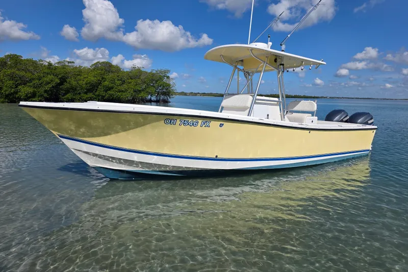 Slide: The Image of 2002 Regulator 26 Center Console boat on calm water under a blue sky. - 2