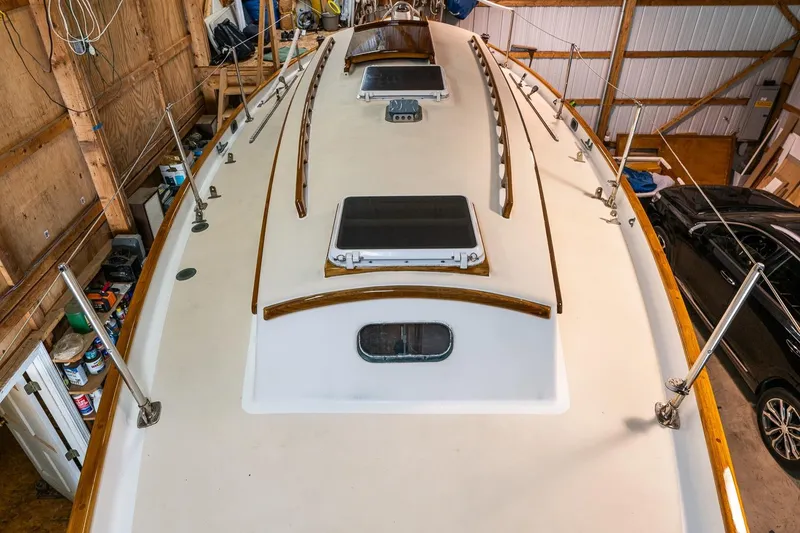 Slide: The Image of 1981 Morris Yachts Leigh 30 sailboat deck in storage, showcasing hatches and wooden trim. - 6