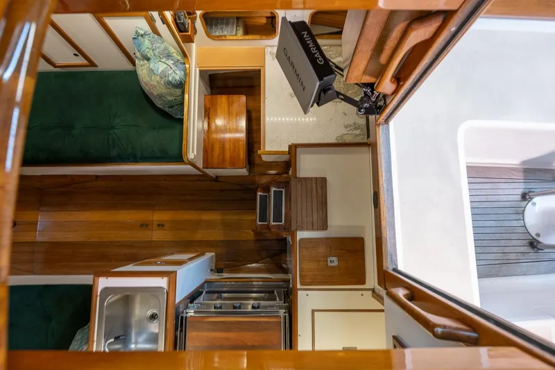 Slide: The Image of Interior view of 1981 Morris Yachts Leigh 30, featuring wood finishes and compact kitchen area. - 13