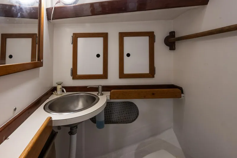 Slide: The Image of Compact bathroom in 1981 Morris Yachts Leigh 30, featuring a stainless steel sink and wooden accents. - 20