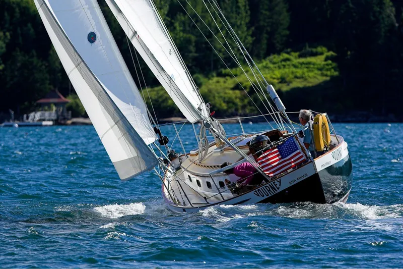 Slide: The Image of Sailing yacht Morris Leigh 30 (1981) navigating blue waters with lush green shoreline. - 37