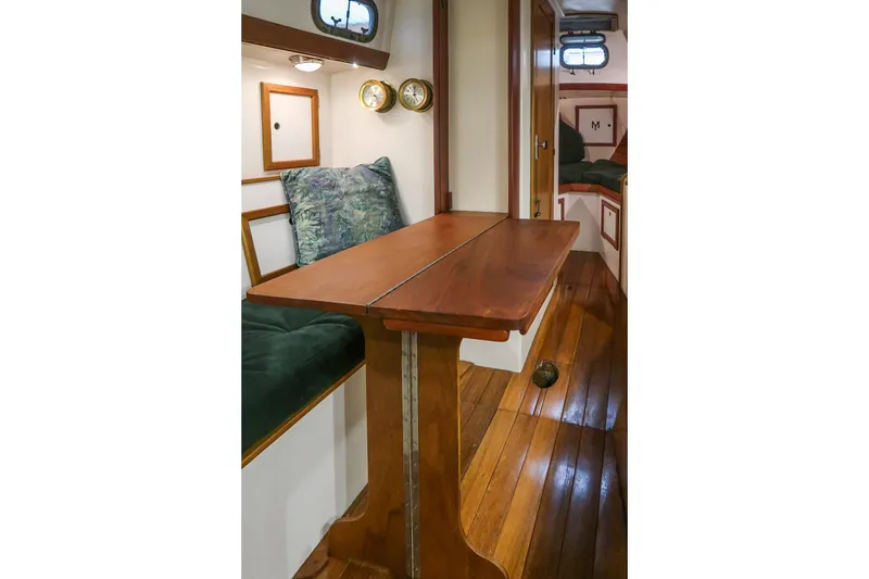 Slide: The Image of Interior of 1981 Morris Yachts Leigh 30, featuring wooden table and cozy seating area. - 33