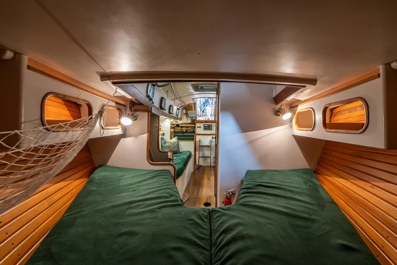 Slide: The Image of Interior of 1981 Morris Yachts Leigh 30, featuring cozy wooden cabin and green bedding. - 23