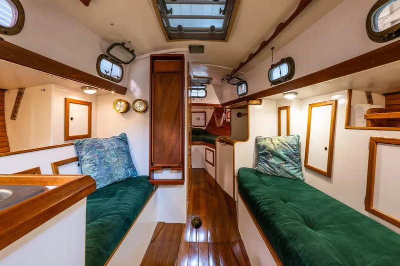 Slide: The Image of Interior of 1981 Morris Yachts Leigh 30 with green cushions and wooden accents. - 14