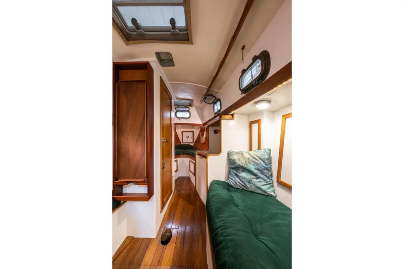 Slide: The Image of Interior of 1981 Morris Yachts Leigh 30, featuring wooden flooring and cozy seating. - 18