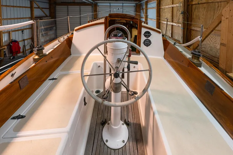 Slide: The Image of Interior view of a 1981 Morris Yachts Leigh 30 sailboat, showcasing the steering wheel and cockpit. - 11