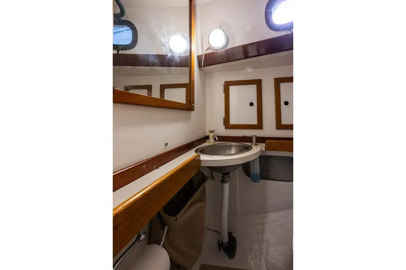 Slide: The Image of 1981 Morris Yachts Leigh 30 bathroom with sink, mirror, and wooden accents. - 21