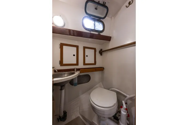 Slide: The Image of 1981 Morris Yachts Leigh 30 yacht bathroom with sink, toilet, and storage cabinets. - 22