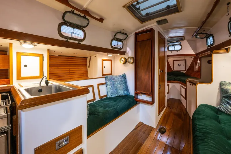 Slide: The Image of Interior of 1981 Morris Yachts Leigh 30, featuring wood accents and green upholstery. - 16