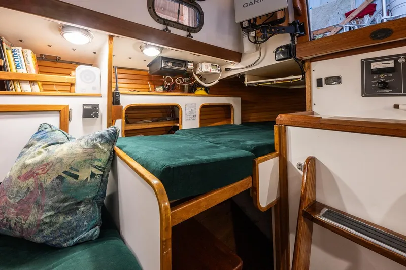 Slide: The Image of Cozy interior of 1981 Morris Yachts Leigh 30 with green cushions and wooden accents. - 26