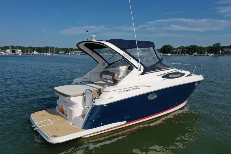 Slide: The Image of 2017 Regal 30 Express boat on calm water, featuring sleek design and spacious deck. - 4