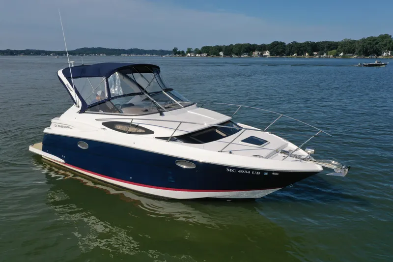 The Image of 2017 Regal 30 Express boat on calm water, featuring sleek design and blue canopy. - 0