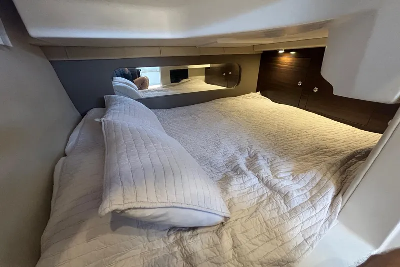 Slide: The Image of Cozy cabin interior of 2017 Regal 30 Express with plush bedding and ambient lighting. - 23