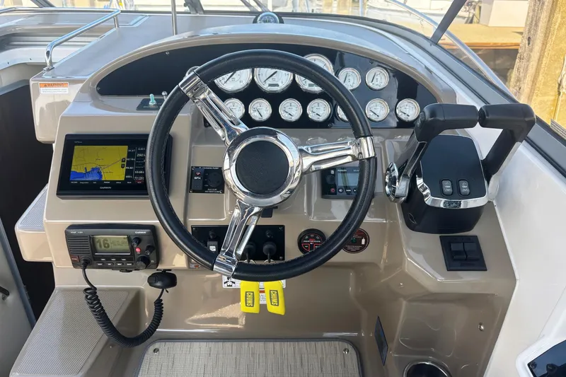 Slide: The Image of Cockpit of 2017 Regal 30 Express boat with steering wheel and navigation controls. - 16