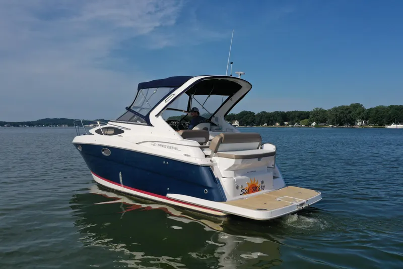 Slide: The Image of 2017 Regal 30 Express boat cruising on a calm lake under a clear blue sky. - 5