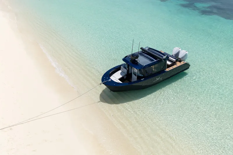 Slide: The Image of A 2026 Jasper Marine Defender 22 boat anchored on a pristine sandy beach. - 3