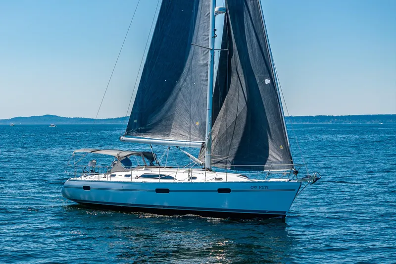 The Image of 2023 Catalina 445 sailboat cruising on open water under clear blue skies. - 0