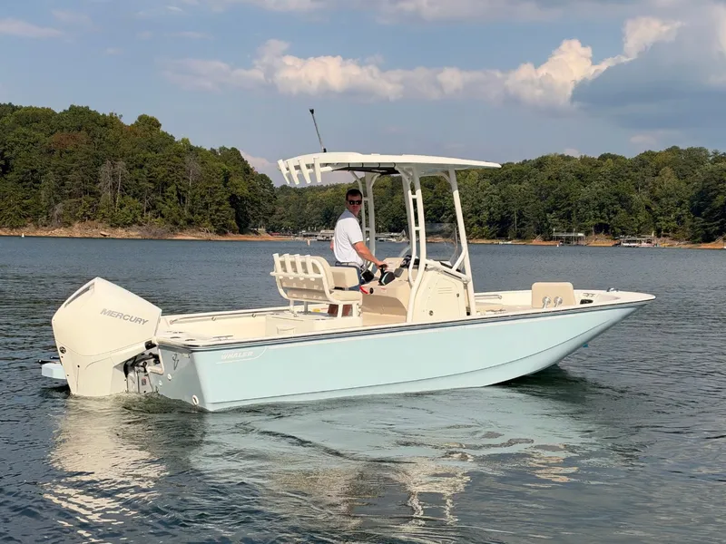 Slide: The Image of Boston Whaler 210 Montauk 2027 on a calm lake with wooded shoreline. - 37