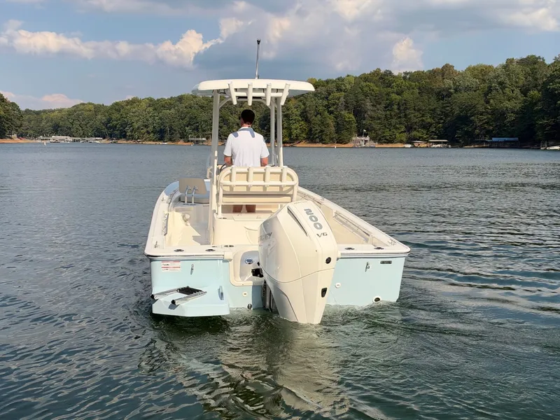 Slide: The Image of A 2027 Boston Whaler 210 Montauk on a calm lake with a wooded shoreline. - 38