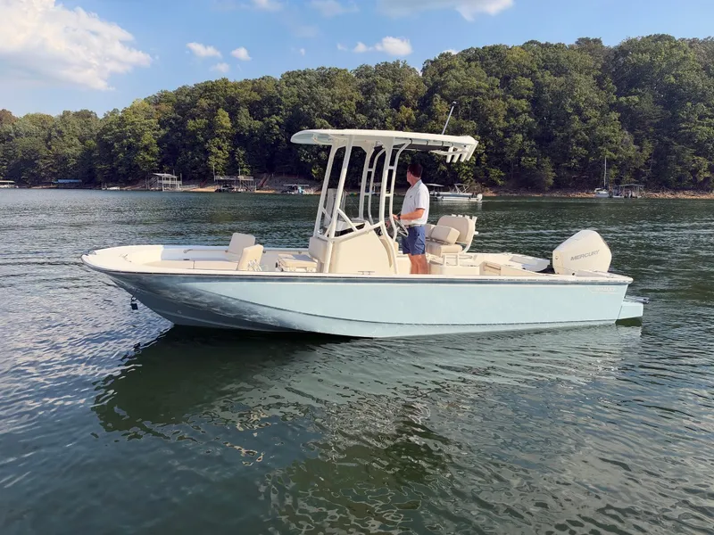 Slide: The Image of A 2027 Boston Whaler 210 Montauk on a calm lake with a wooded shoreline. - 43