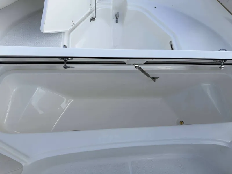 Slide: The Image of An open storage compartment on a Boston Whaler 210 Montauk boat, featuring a white interior. - 27