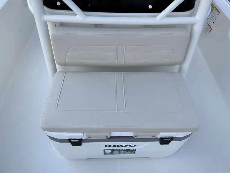 Slide: The Image of The 2027 Boston Whaler 210 Montauk features a cushioned bench seat over an Igloo cooler. - 19