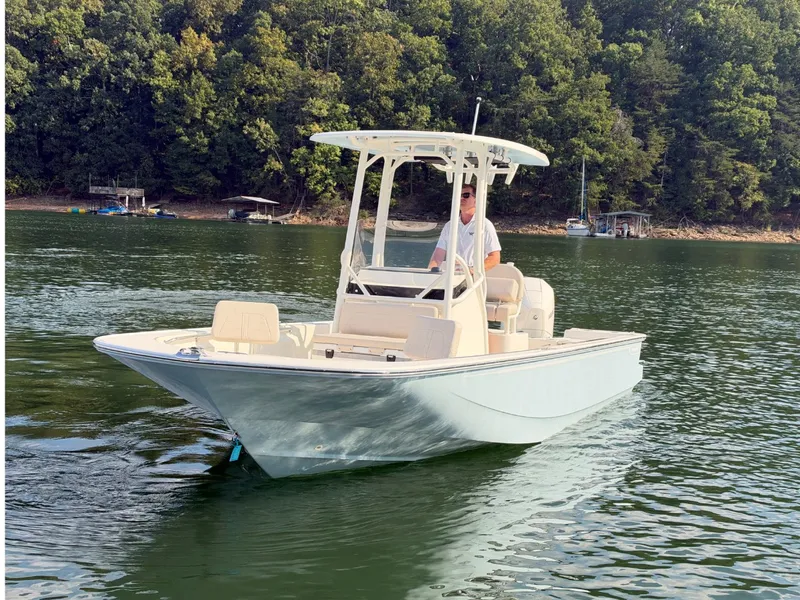 Slide: The Image of A 2027 Boston Whaler 210 Montauk on a calm lake with a wooded shoreline. - 28