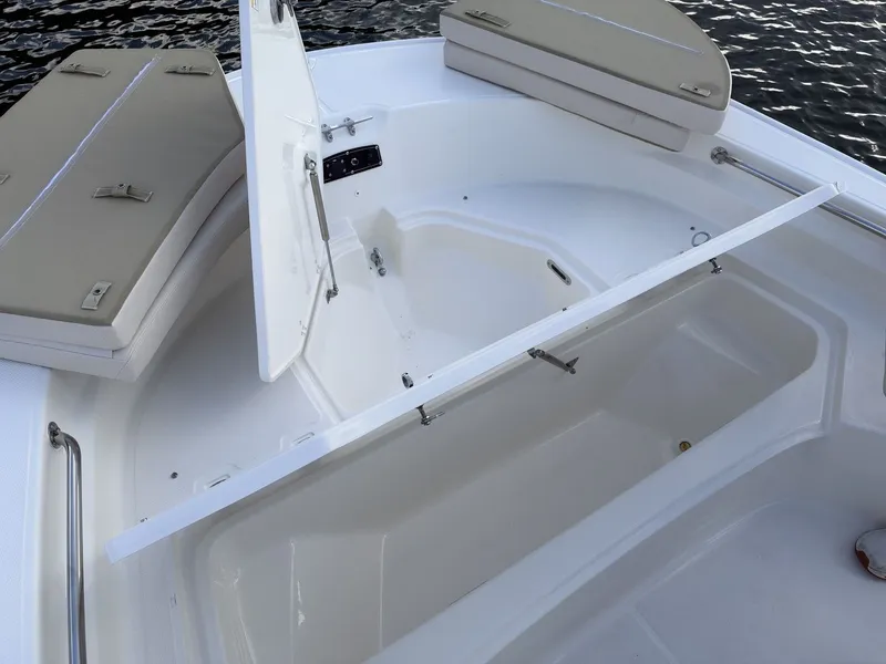 Slide: The Image of The image shows the bow area of a Boston Whaler 210 Montauk with open storage compartments. - 24