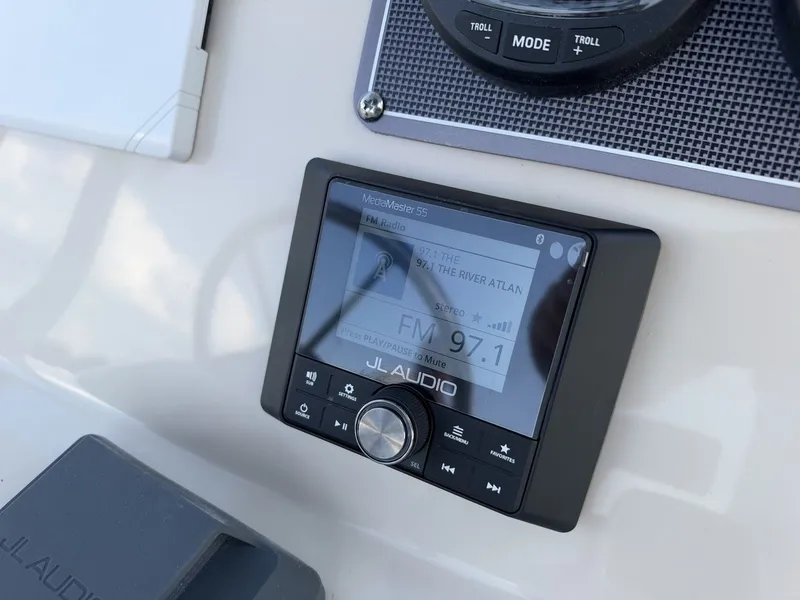 Slide: The Image of Close-up of a JL Audio control unit on a boat, displaying FM radio. - 16