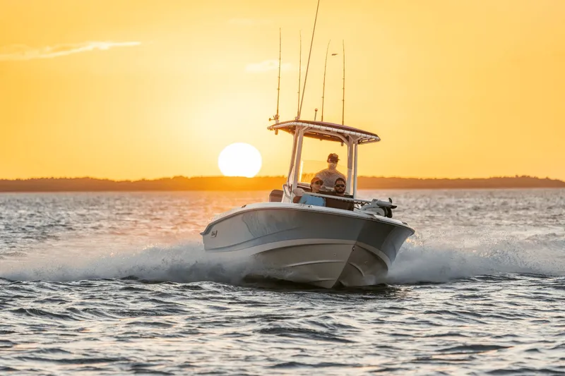 Slide: The Image of Boston Whaler 220 Dauntless cruising on the water at sunset. - 13