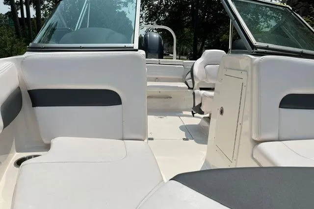 Slide: The Image of 2021 Chaparral 19 SSi OB boat interior with white seating and open deck layout. - 5