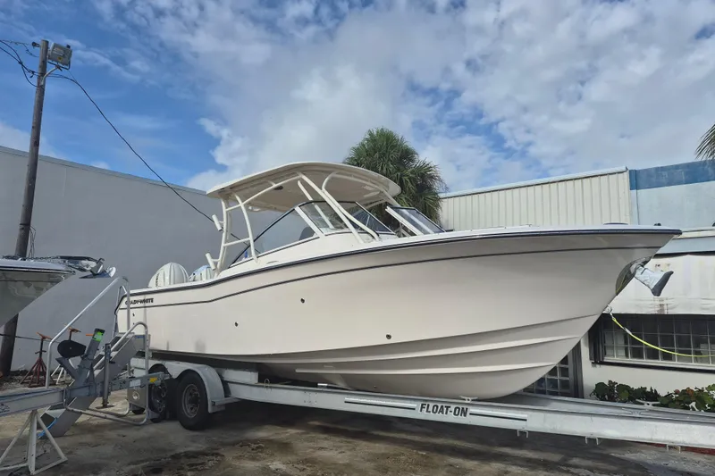 The Image of 2026 Grady-White Freedom 275 boat on trailer, parked outdoors under a cloudy sky. - 0