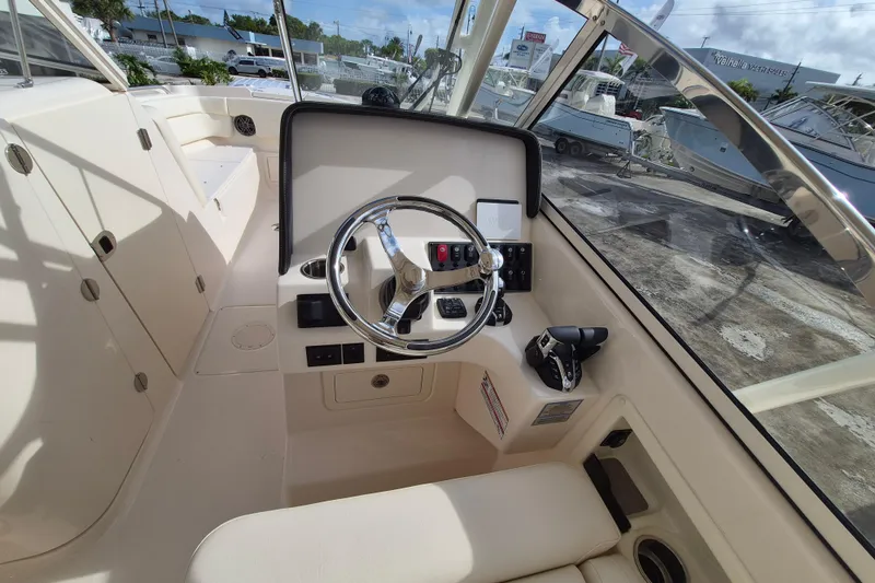 Slide: The Image of 2026 Grady-White Freedom 275 boat cockpit with steering wheel and controls. - 9