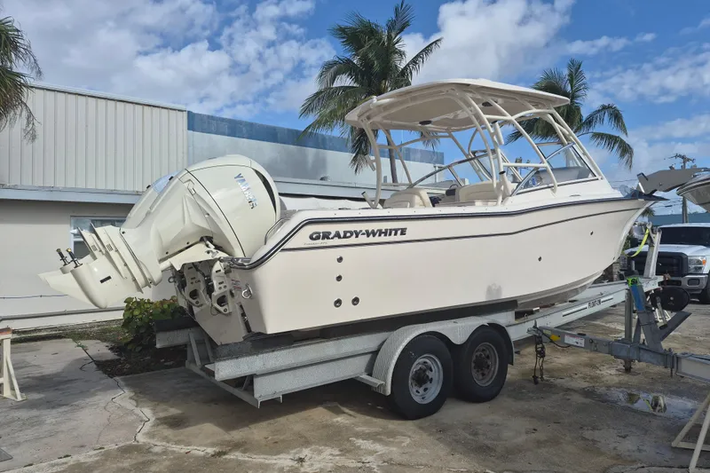 Slide: The Image of 2026 Grady-White Freedom 275 boat on trailer, parked outdoors under blue sky. - 1