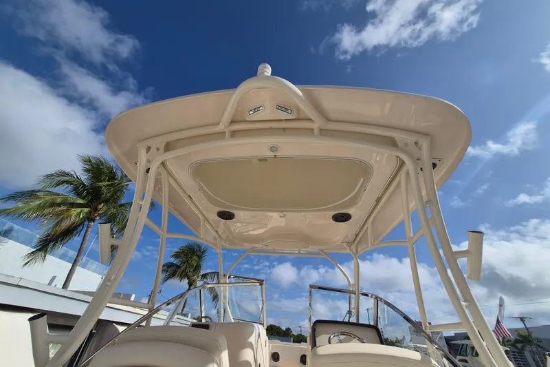Slide: The Image of 2026 Grady-White Freedom 275 boat with hardtop against a blue sky and palm trees. - 4
