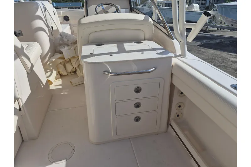 Slide: The Image of Interior view of a 2026 Grady-White Freedom 275 boat, featuring storage drawers and seating. - 13