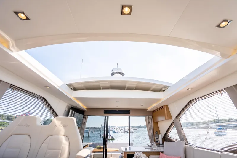 Slide: The Image of Interior view of 2017 Sea Ray Sundancer 460 yacht with open sunroof and waterfront scenery. - 36
