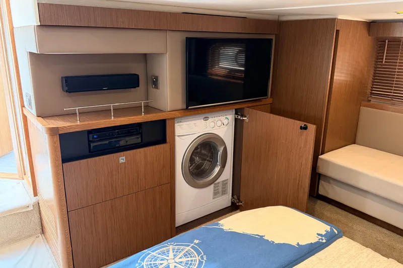 Slide: The Image of Interior of 2017 Sea Ray Sundancer 460 yacht with TV, washer, and wooden cabinetry. - 42