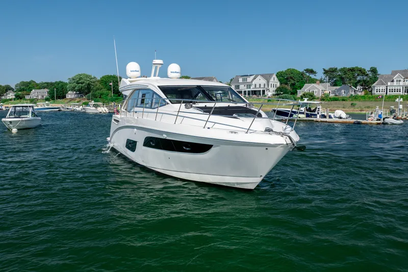 Slide: The Image of 2017 Sea Ray Sundancer 460 yacht cruising in a scenic coastal harbor. - 10