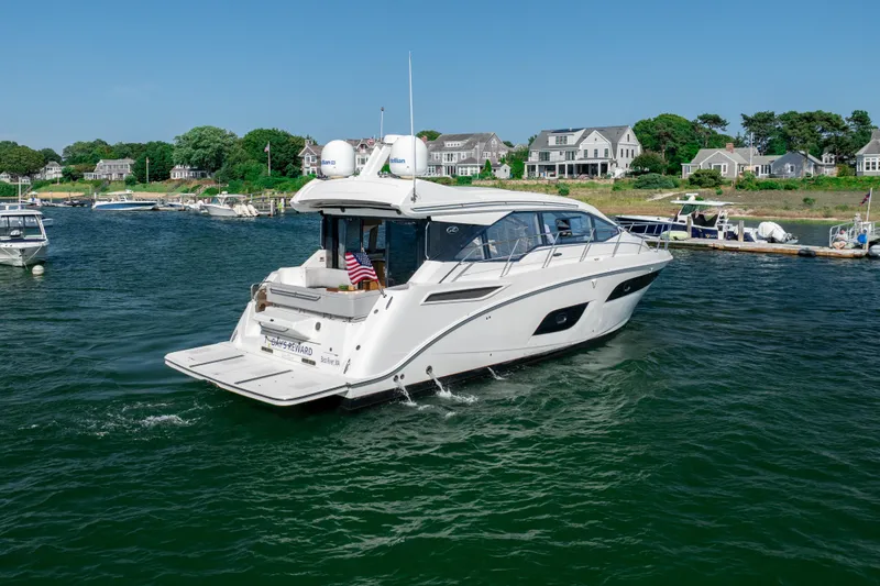 Slide: The Image of 2017 Sea Ray Sundancer 460 yacht cruising near coastal homes on a sunny day. - 7