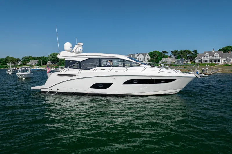 Slide: The Image of 2017 Sea Ray Sundancer 460 yacht cruising near coastal homes on a sunny day. - 6