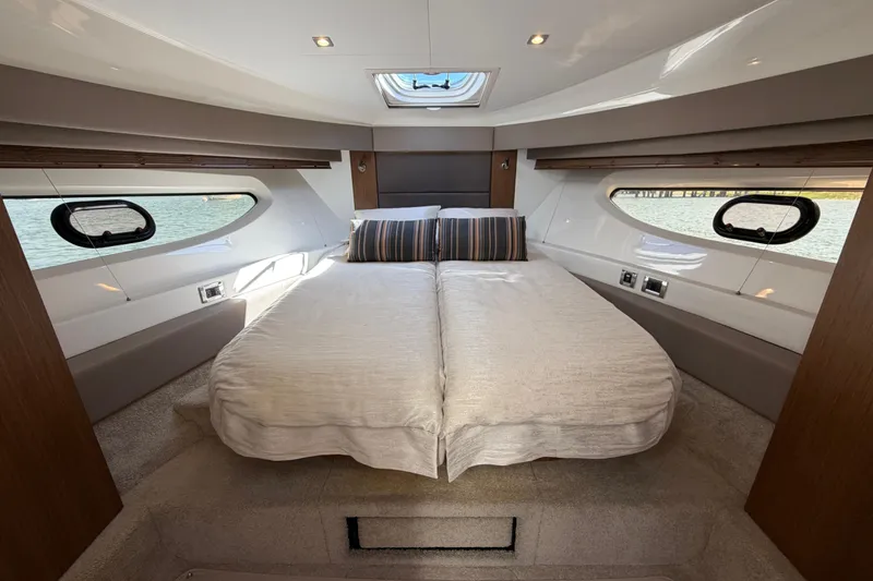 Slide: The Image of Luxurious 2017 Sea Ray Sundancer 460 cabin interior with elegant bedding and scenic windows. - 32