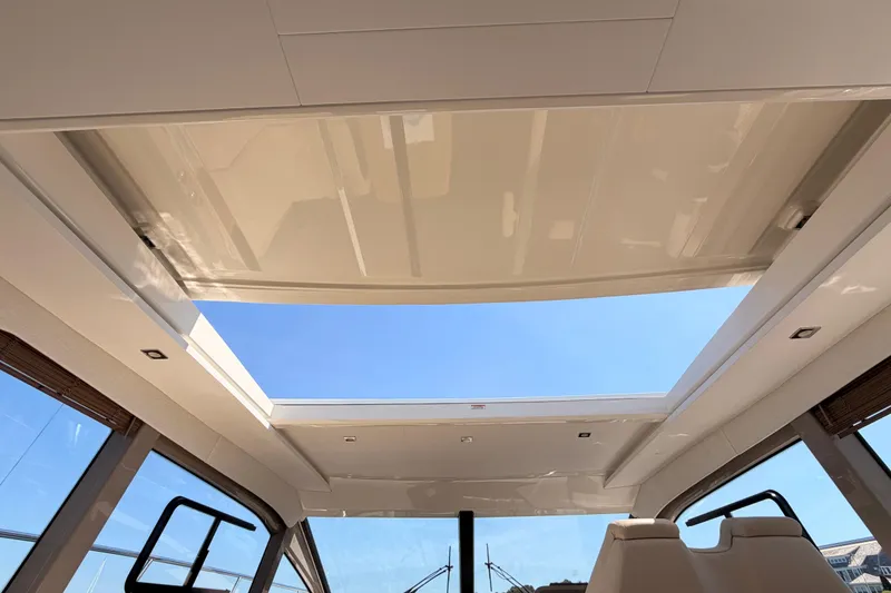 Slide: The Image of 2017 Sea Ray Sundancer 460 yacht interior with open sunroof and clear blue sky. - 20