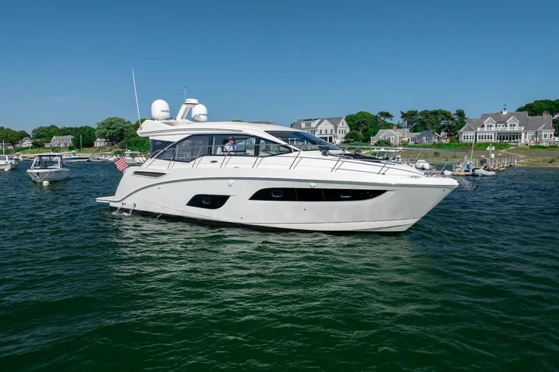 Slide: The Image of 2017 Sea Ray Sundancer 460 yacht cruising near coastal homes on a sunny day. - 8